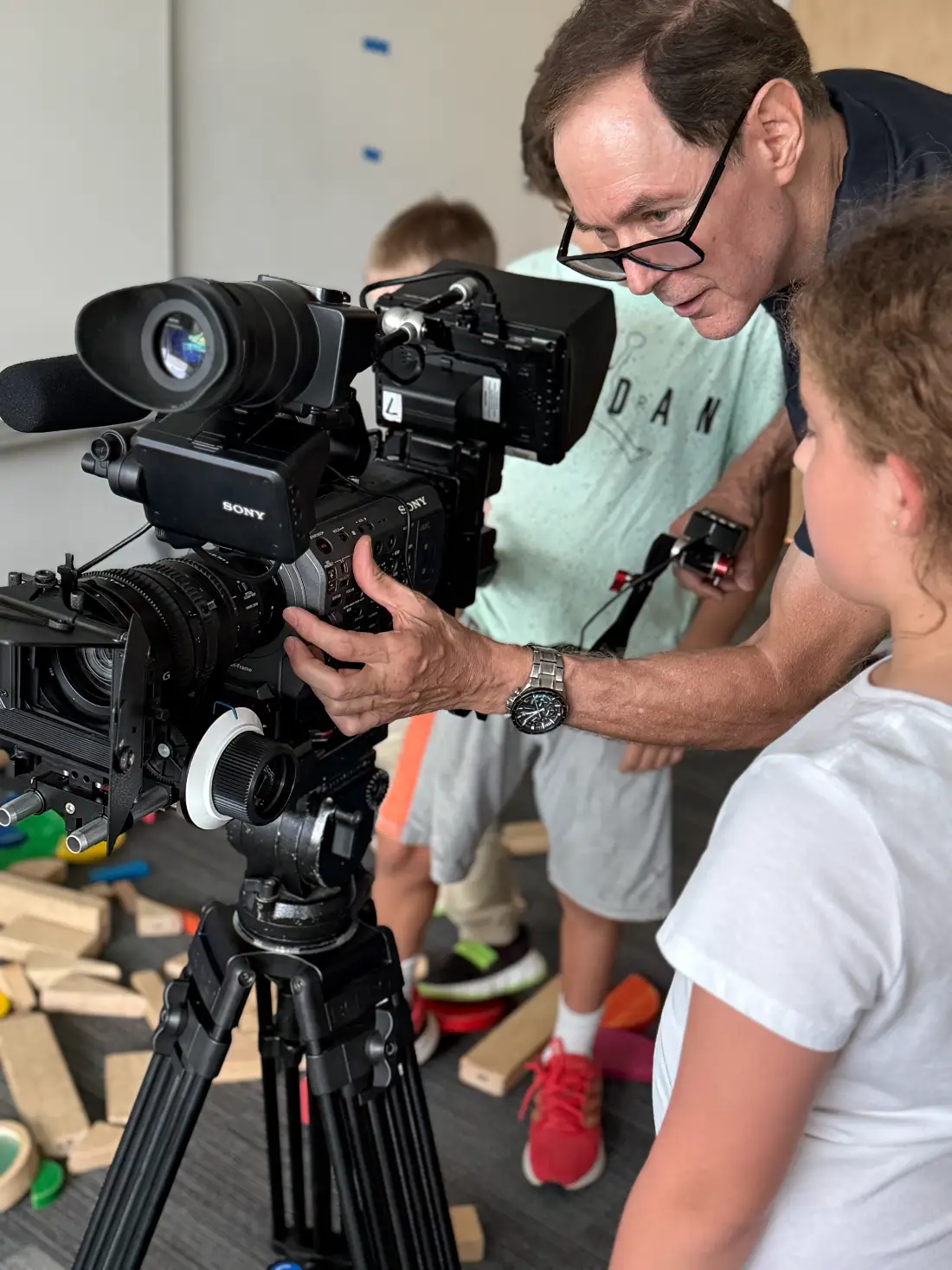 An instructor showing a camper how to work the Sony camera on set