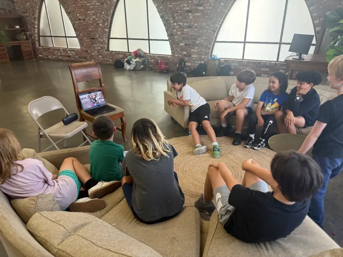 An after-school filmmaking class for kids watching a scene back together
