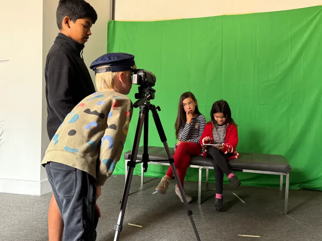 A camper operating the camera while the cast waits on set
