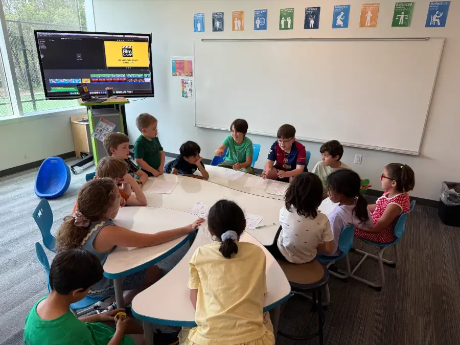 A camp crew round the table reading their script together