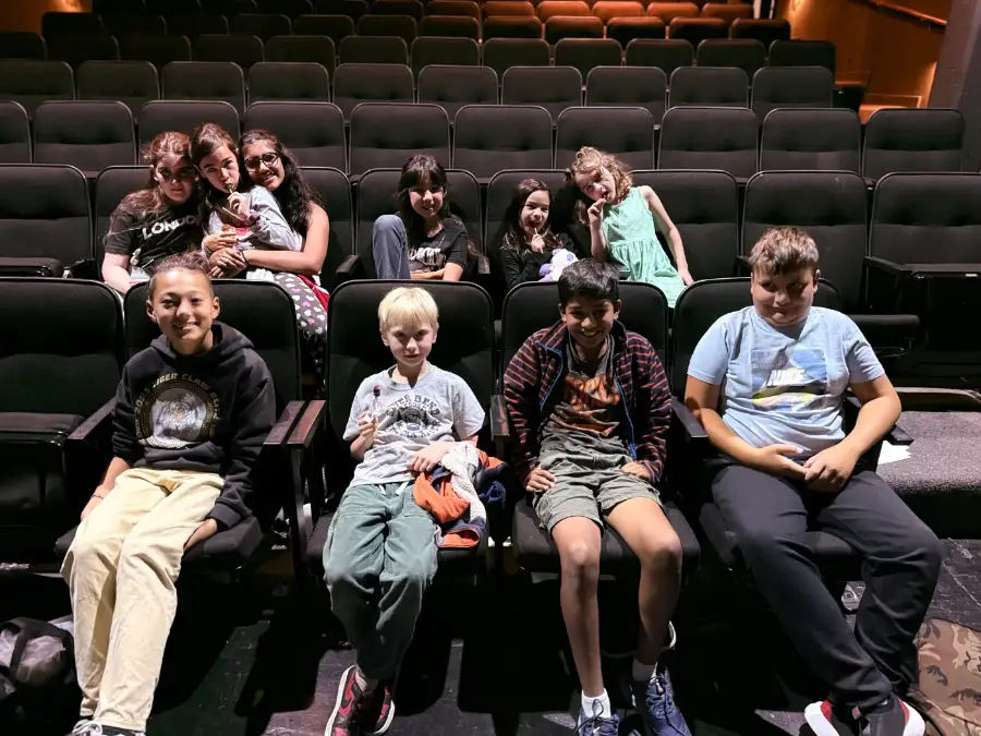 A camp crew filling the theatre seats, waiting for their film to start